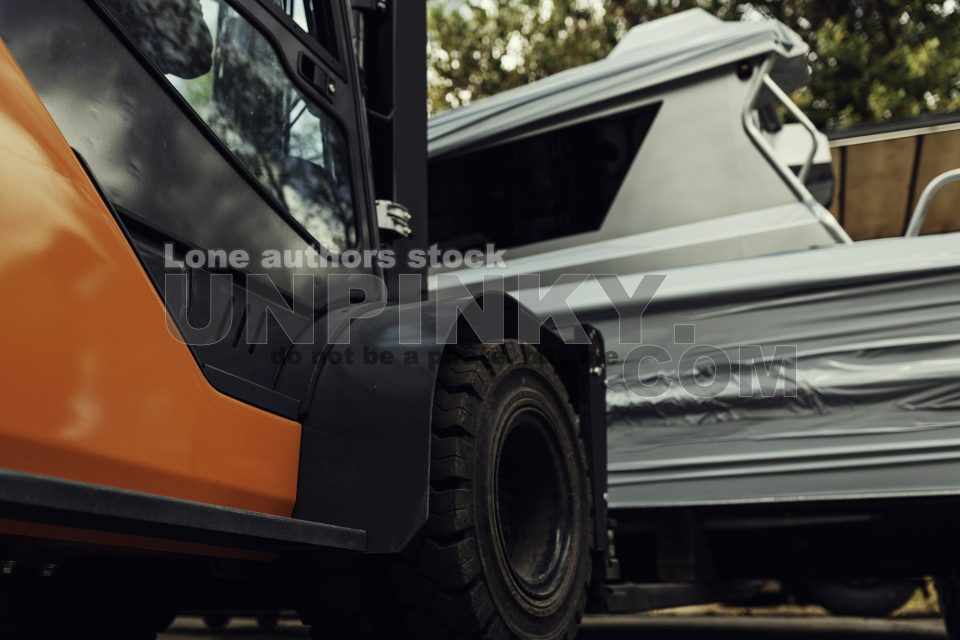 A forklift lifts a motor yacht