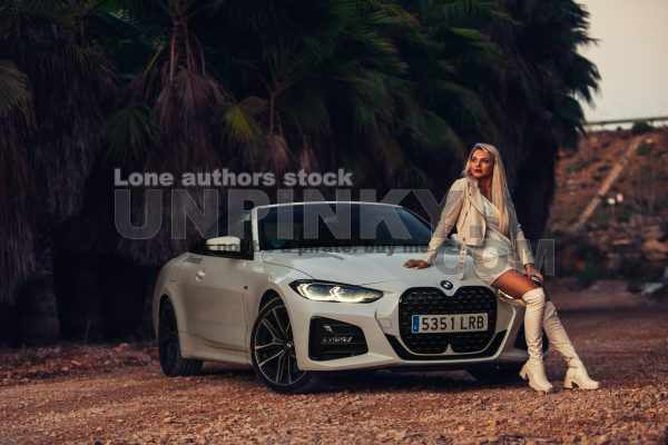 Woman near BMW 430I convertible between palms | Editorial