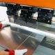 Factory worker bending steel at the machine