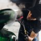 A man makes a detailing of a new car and use a steam to wrap a mirror