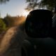 Car in forest at the evening . Sun rays of sun and mirror silhouette. Sunrise in tropics during off-road trip