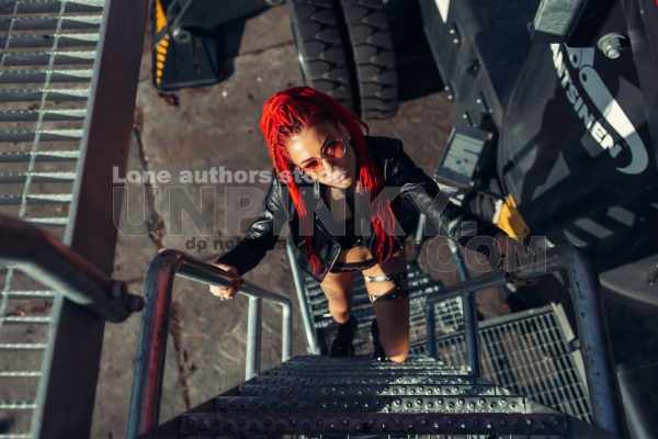 Beautiful girl with dreadlocks and red hair at a construction site