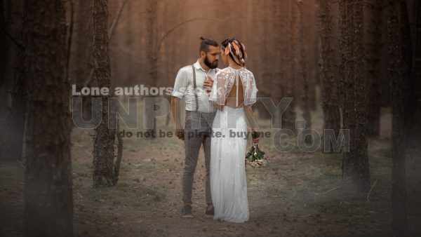 Modern bride and groom stand at the wood