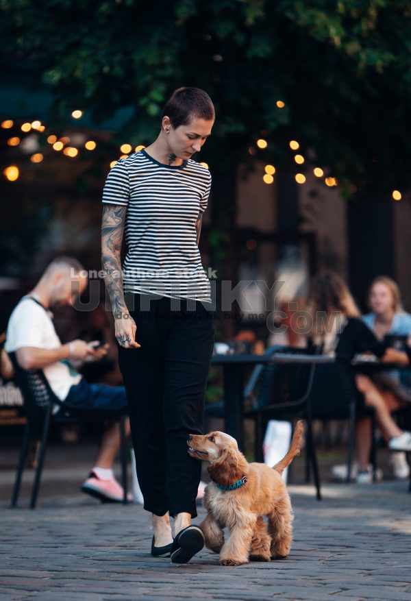 Modern tattooed girl walking with her Cocker Spaniel puppy