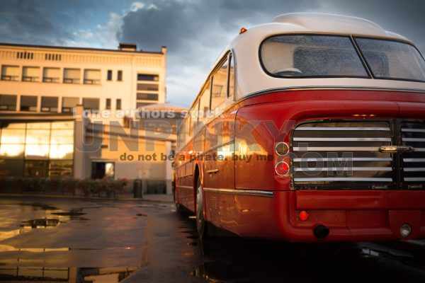 Classic red bus at the central station station at the early morning after rain
