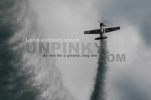 Small airplane make a loop with smoke trails at the airshow