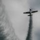 Small airplane make a loop with smoke trails at the airshow