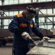 Factory worker polish and cut off a metal part