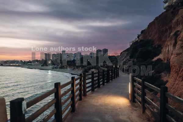Beautiful promenade in the late evening along the sea and rocks in Alicante