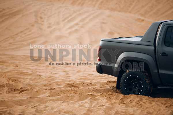 Modern pickup truck car rear side at the middle of desert. Car at the off-road