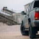Pick up SUV car at the gravel carrier. Back view of the truck on the rural road. The army truck is stopped at the gravel.