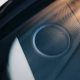 Round speakers in a modern car panel with sun set reflection