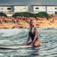 Young beautiful woman relaxing in the sea on a surf board