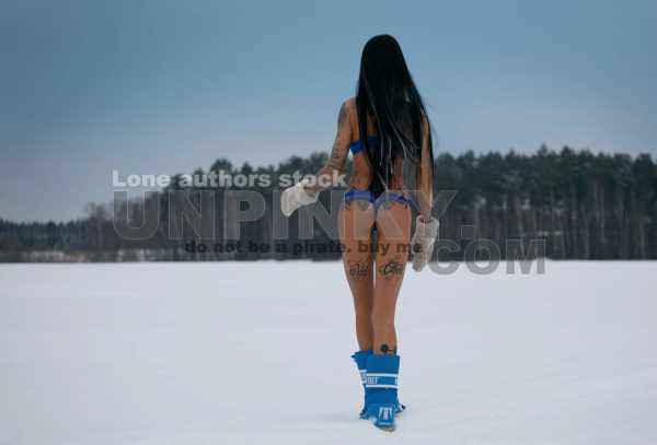 Sexy naked woman with tattoo on snow field at winter