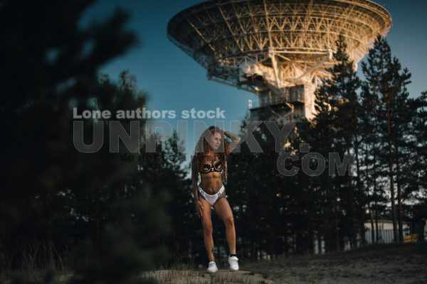 Sexy tattooed woman near satellite dish antenna