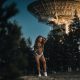 Sexy tattooed woman near satellite dish antenna