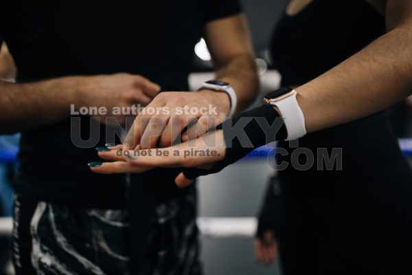 Trainer help to tape woman hand with a sport belt before kickboxing