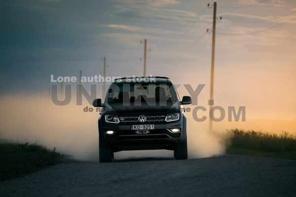Volkswagen Amarok on dirt road go fast with a clouds of dust