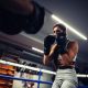 A girl in boxing training at the ring with a trainer