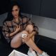 Stylish young woman relaxing in a modern kitchen with coffee at the morning.