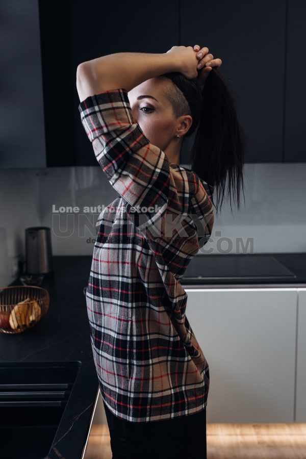 Stylish young woman relaxing in a modern kitchen with coffee in the morning. Modern kitchen with backlight. Lady is resting before working day
