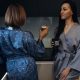 Stylish young woman relaxing in a modern kitchen with coffee in the morning. Modern kitchen with backlight. Lady is resting before working day