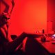 A woman drinks in the kitchen of her apartment in the evening