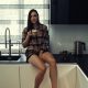 Stylish young woman relaxing in a modern kitchen with coffee at the morning.
