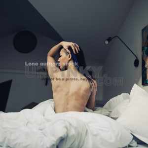 Attractive women wake up in the morning in the modern bright hotel room. Naked neck of beautiful lady at the morning