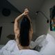 Attractive woman wake up in the morning in the modern bright hotel room. Naked neck of beautiful lady at the morning