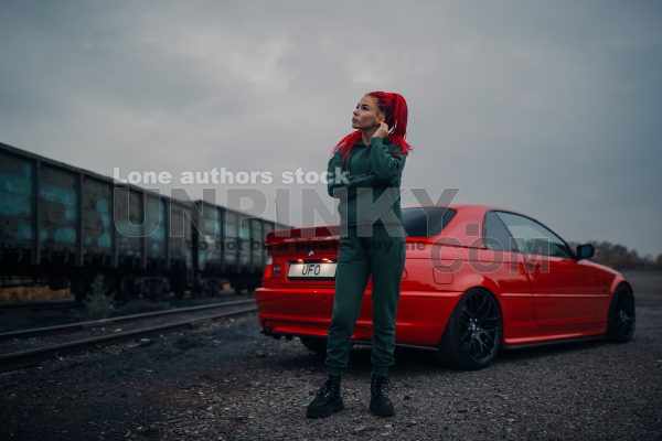 Woman with long red hairs near coupe car