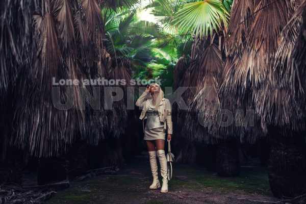Young woman between palms forest