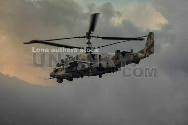 Military helicopter in the sky. Warplane fly low pass at the evening sky