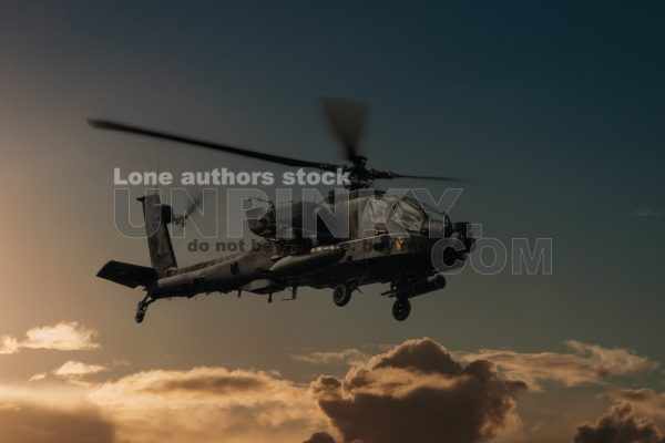 Military helicopter in the sky. War plane fly low pass at the evening sky