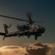 Military helicopter in the sky. War plane fly low pass at the evening sky