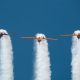Aerobatic team performing a loop at small planes