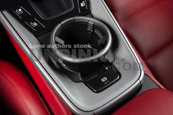 Modern car cup holder close up. Sports car luxury and expensive coupe dashboard panel with mug holder. Luxury interface of new car