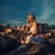 A Stunning Woman Enjoys the Tranquil Sunset by the Sparkling Sea, Embracing the Calming Moment of Nature’s Majesty
