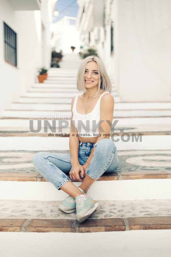 Beautiful woman is sitting at the stair case of old city