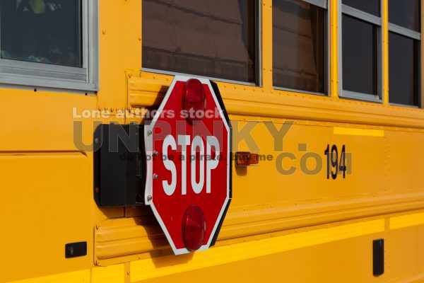 Stop road sign at the school bus