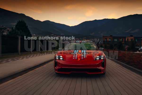 Porsche Taycan Turbo S going fast on the highway and beautiful mountains at the background