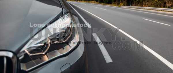 Modern car headlight close up view on the highway